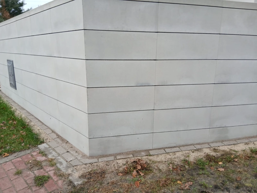 Ogrodzenie betonowe z gładkich paneli w narożniku posesji