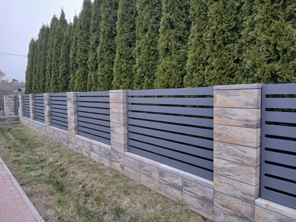 Nowoczesne ogrodzenie żaluzjowe z poziomych paneli na cokołach z płytek klinkierowych