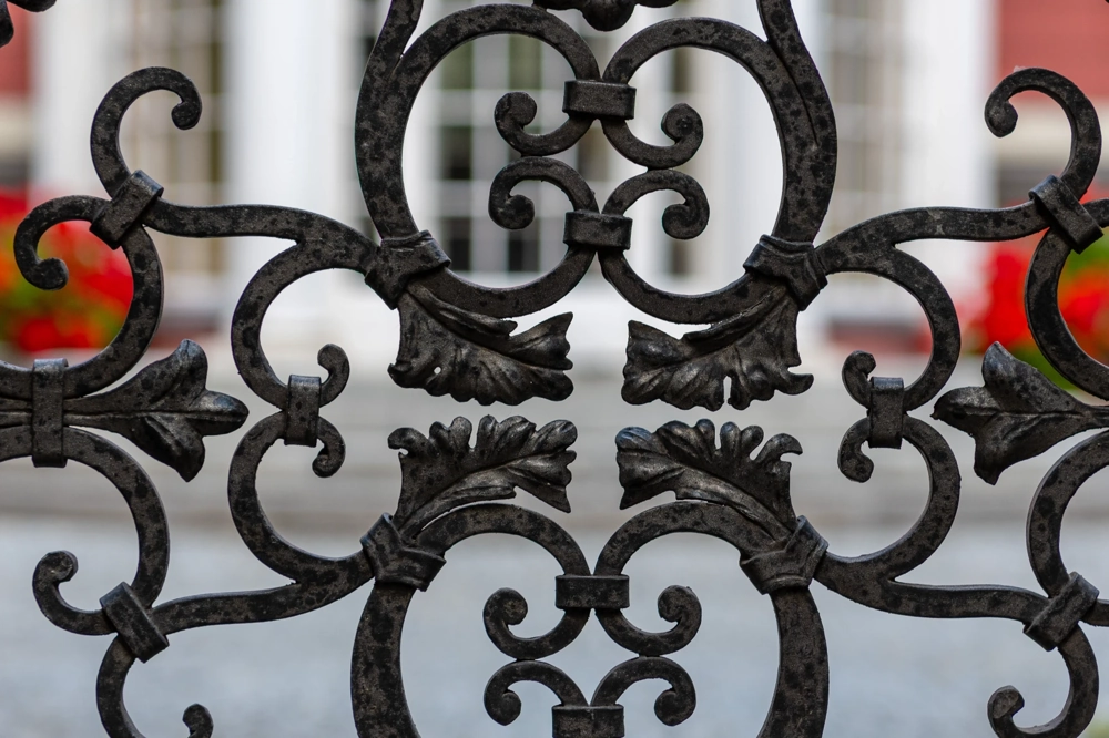 Ogrodzenia kute z dekoracyjnym motywem liści i symetrycznych zawijasów zbliżenie